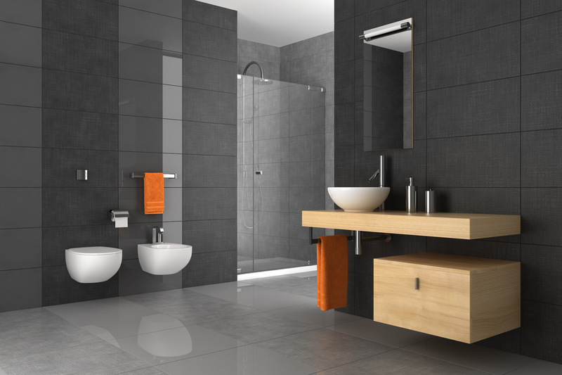 Badezimmer mit großformatigen dunklen Fliesen, Glasdusche und Waschtisch in Holzoptik
