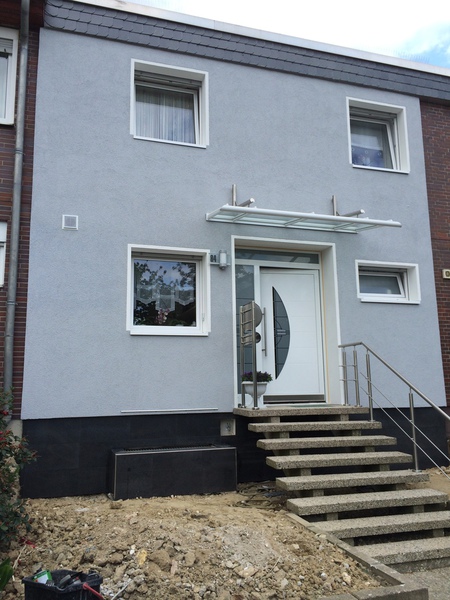 Verputzte Hausfassade mit Eingangstreppe